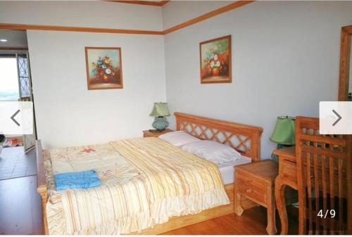a bedroom with a bed with two pictures on the wall at Rayong VIP condo Thai style in Ban Phe