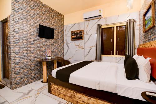 Un dormitorio con una cama y una pared de ladrillo. en Hotel O ARES RESIDENCY, en Puri