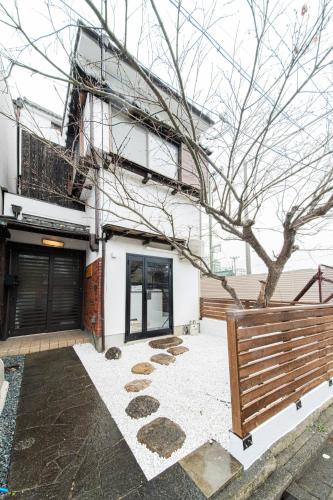a house with a tree in front of it at 夏様四条大宮 Private Machiya house, Kyoto city center, 5 min walk Shijo Omiya in Kyoto