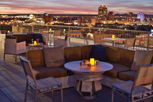 a rooftop bar with a couch and tables and chairs at Hotel Parq Central Albuquerque in Albuquerque