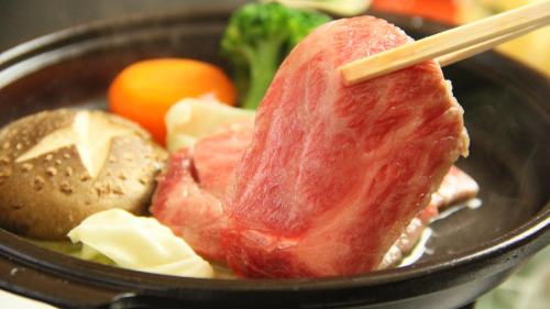 a piece of meat and other food in a pan at Gokayama Onsen Akaokan in Nanto