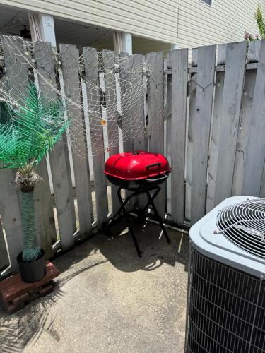 a red stool sitting in front of a fence at Family Beach house in Myrtle Beach