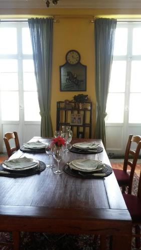 une table en bois avec des assiettes et des verres à vin dessus dans l'établissement Chambres de Charme a la Ferme, à Épinay-sur-Odon