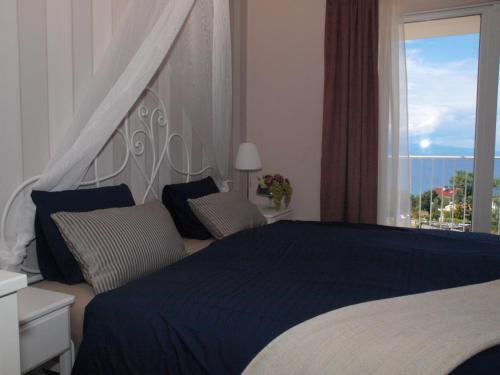 a bedroom with a large bed with a large window at Guesthouse Olei in Malinska