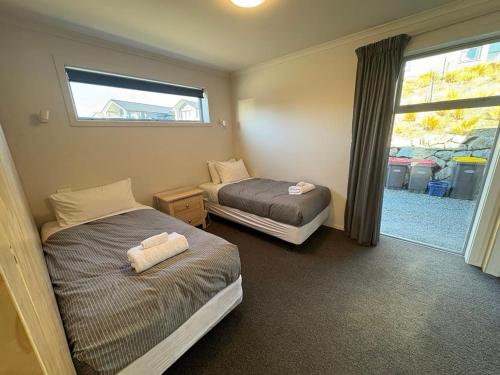 a bedroom with two beds and a window with a window at Haps in Lake Tekapo