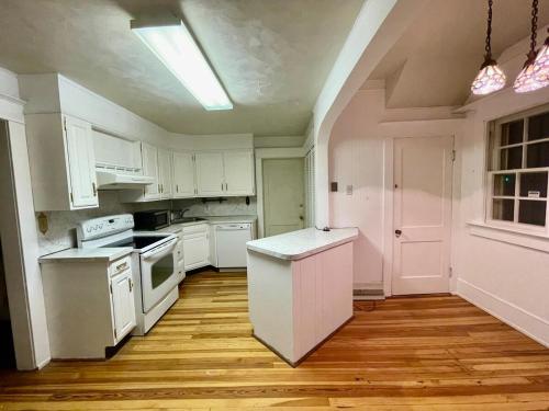 a kitchen with white appliances and a wooden floor at Family-Friendly Home Near Sesame Place 2 King Beds in Morrisville