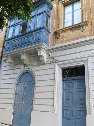 a building with a blue door and a window at 17 Domus Mariae Town House in Senglea