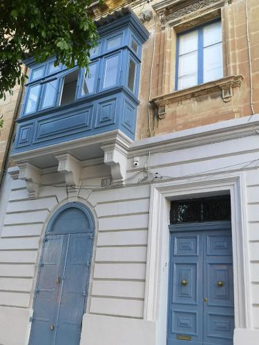 a building with a blue door and a window at 17 Domus Mariae Town House in Senglea