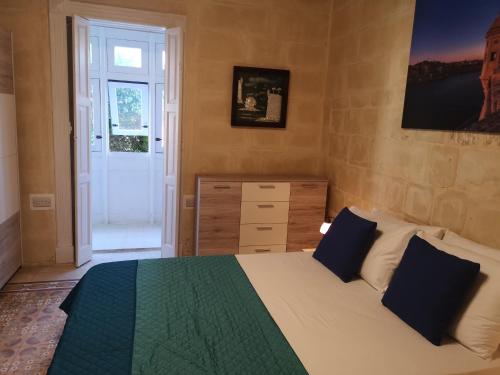 a bedroom with a bed and a dresser and a window at 17 Domus Mariae Town House in Senglea
