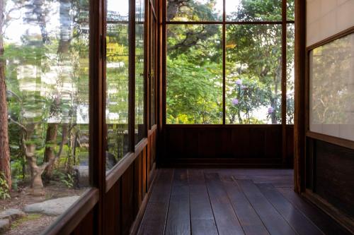 an empty room with large windows and trees at Gamagori Classic Hotel in Gamagori