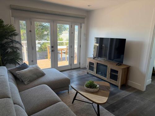 a living room with a couch and a flat screen tv at Cozy Guesthouse with Modern Appliances & Private Patio in San Francisco