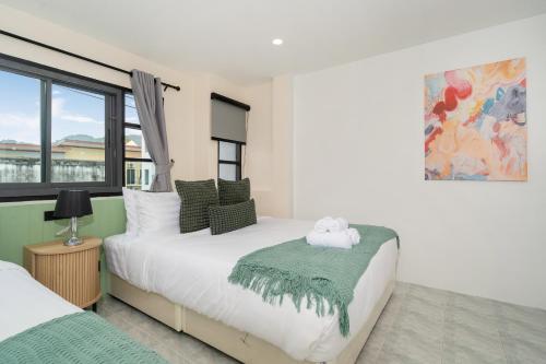 a bedroom with two beds and a large window at Wink 3 Patong Beach Phuket sleep 8 in Ban Nong Chaeng