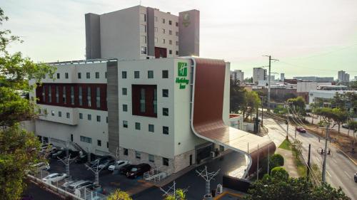 a building with a spiral staircase in a city at Holiday Inn Guadalajara Patria-Universidad by IHG in Guadalajara