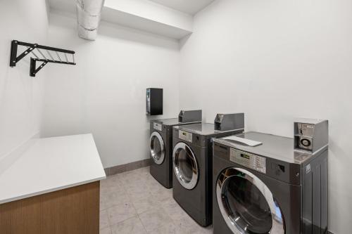 a laundry room with three washing machines and a counter at Holiday Inn Express Asheville Woodfin by IHG in Asheville