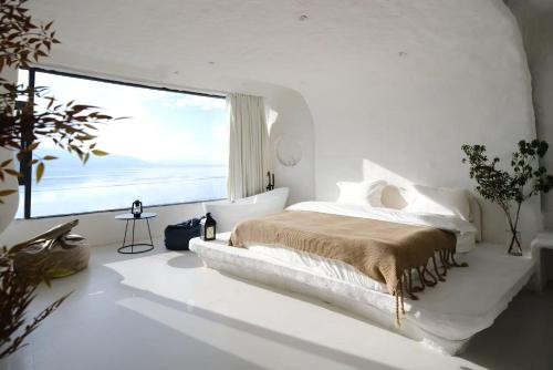 香格里拉Shanyuhai Pure White Cave Sea View Holiday Hotel View Designer Hotel的一间带床和大窗户的白色卧室