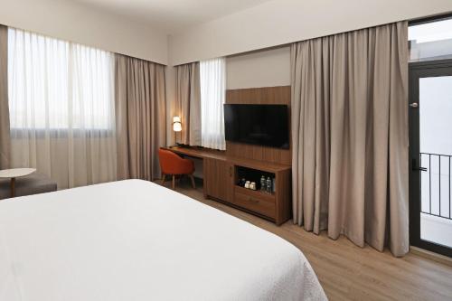 a hotel room with a bed and a flat screen tv at Holiday Inn Navojoa by IHG in Navojoa