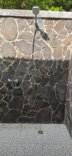 a stone wall with a hose on top of it at Uma Nirmala Aling-Aling in Singaraja