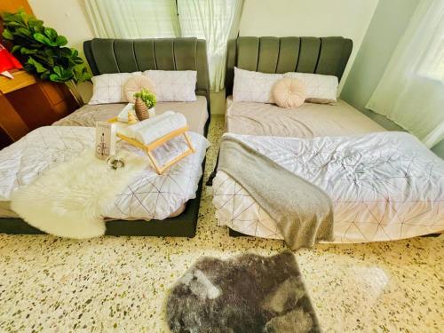 a room with two beds with blankets and pillows at Laksamana Homestay in Batu Pahat