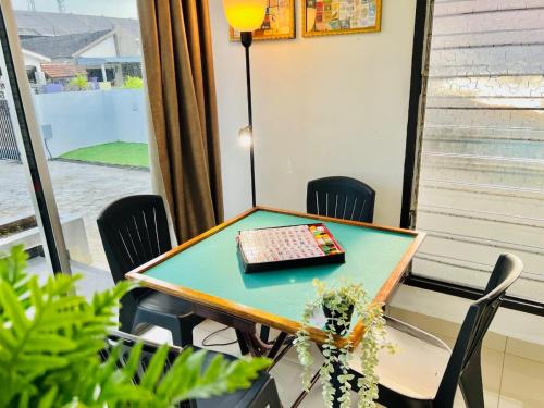 a table with a book on it in a room with chairs at Laksamana Homestay in Batu Pahat