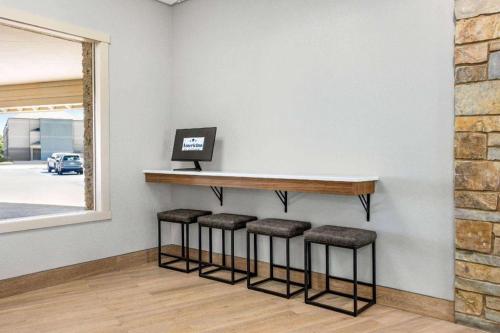 a bar with stools in a room with a wall at AmericInn by Wyndham La Crosse Riverfront-Conference Center in La Crosse