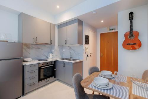 een keuken met een tafel en een gitaar aan de muur bij Studio 4, Kalamata in Kalamata