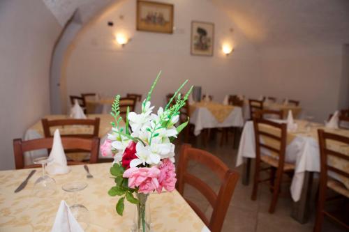 a vase of flowers on a table in a restaurant at Agriturismo da Regina in Tramonti