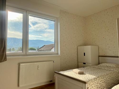 a bedroom with a bed and a large window at The Corner Apartment in Martin