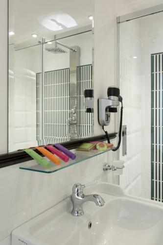 a bathroom with a sink and a mirror and some markers at Relais Donna Lucrezia in Rome