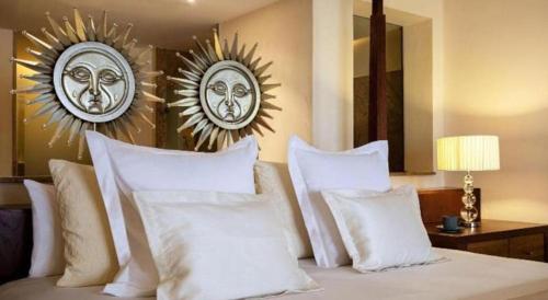 a bedroom with a bed with white pillows and two mirrors at Excellence Playa Mujeres- All Inclusive- Adults Only in Cancún