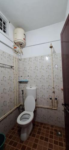a bathroom with a white toilet in a room at Holiday Apartments & Homestay in Sultan Bathery