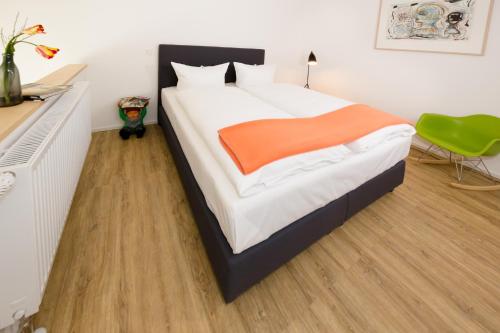 a bedroom with a large bed with an orange blanket at Country Inn Suitenhotel in Werder