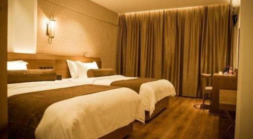 a hotel room with two beds and a window at James Joyce Coffetel Qufu Tourist Center Gulou Street Sankong Scenic Spot in Jining