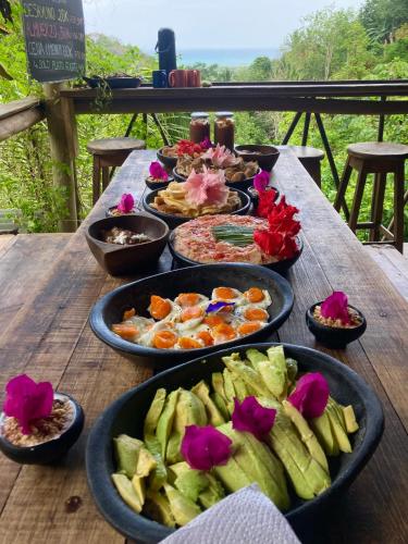 a wooden table with many dishes of food on it at Finca La Selvita Chocolate experience in Buritaca