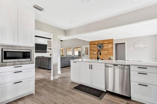 a kitchen with white cabinets and a living room at Jacuzzi Lakefront Home w/ Game room+play structure in Rockwall