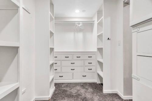 a white walk in closet with white shelves at Jacuzzi Lakefront Home w/ Game room+play structure in Rockwall
