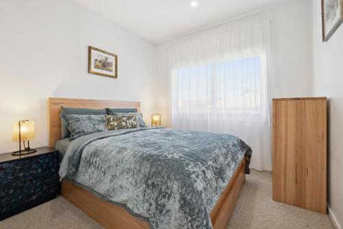 a bedroom with a large bed and a window at The Crystal Palace 2 in Jindabyne