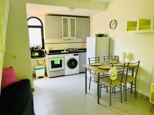 a kitchen with a table and chairs and a refrigerator at Oasis del Sol in Costa Calma