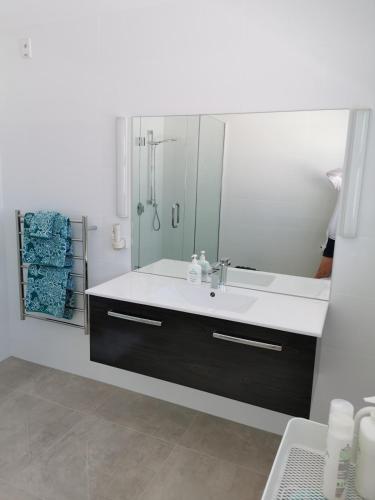 a bathroom with a sink and a mirror at Mountain View Townhouse, New Plymouth in New Plymouth