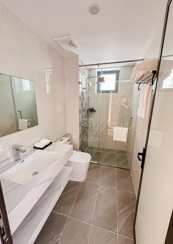 a bathroom with a sink and a toilet and a shower at Binh Minh Bac Ha Hotel in Bắc Hà