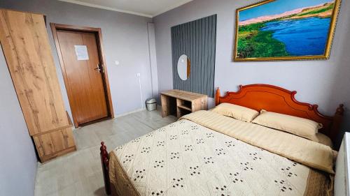 a bedroom with a bed with a wooden head board at Gaya's Guest House in Harhorin