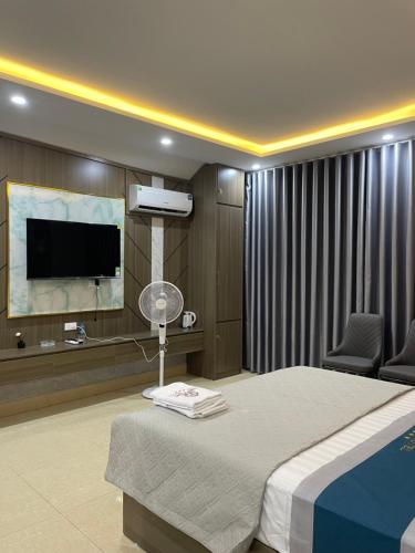 a hotel room with a bed and a flat screen tv at Ruby 3 Hotel in Hanoi
