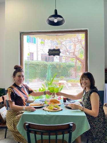 two women sitting at a table with a plate of food at Thala Hotel Sorrento in Phú Quốc