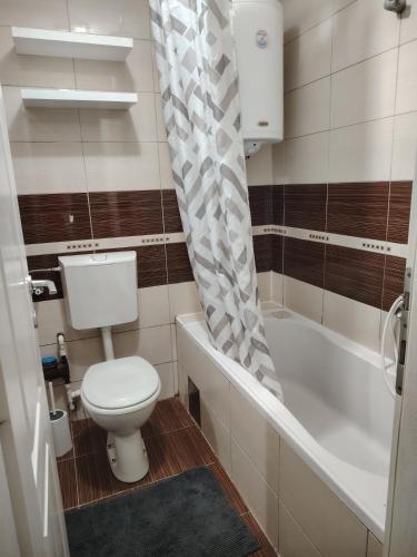a bathroom with a toilet and a shower curtain at Sofi in Jagodina