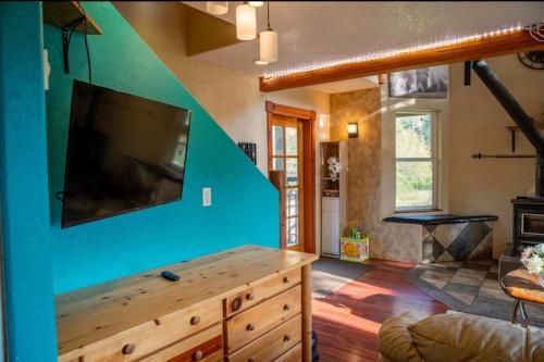 a living room with a flat screen tv on a blue wall at Maple Haven Cabin in Maple Falls
