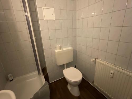 a white bathroom with a toilet and a shower at Pension Markt Neustrelitz in Neustrelitz