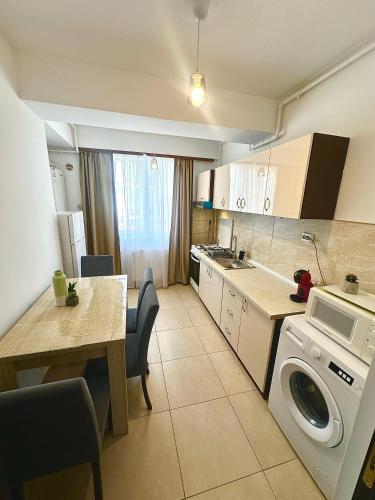 a kitchen with a table and a washing machine at Summerland Seaview Apartments in Mamaia
