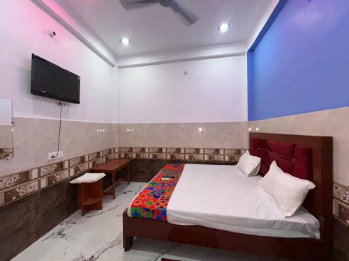a bedroom with a bed and a tv on the wall at Hotel S!ya Ram Ayodhya Near Ram Janam Bhoomi & Temple - fully Air Conditioned hotel at Prime Location - Parking-Wi-Fi -Lift Facilities - Best Hotel In Ayodhya in Ayodhya