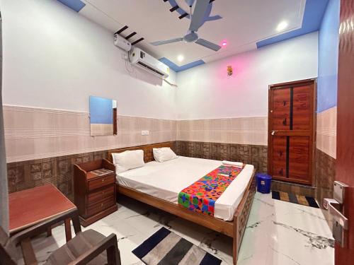 a bedroom with a bed and a table and a tv at Hotel S!ya Ram Ayodhya Near Ram Janam Bhoomi & Temple - fully Air Conditioned hotel at Prime Location - Parking-Wi-Fi -Lift Facilities - Best Hotel In Ayodhya in Ayodhya