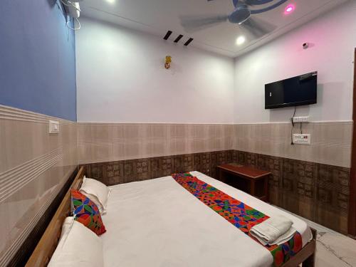a room with a bed and a flat screen tv at Hotel S!ya Ram Ayodhya Near Ram Janam Bhoomi & Temple - fully Air Conditioned hotel at Prime Location - Parking-Wi-Fi -Lift Facilities - Best Hotel In Ayodhya in Ayodhya