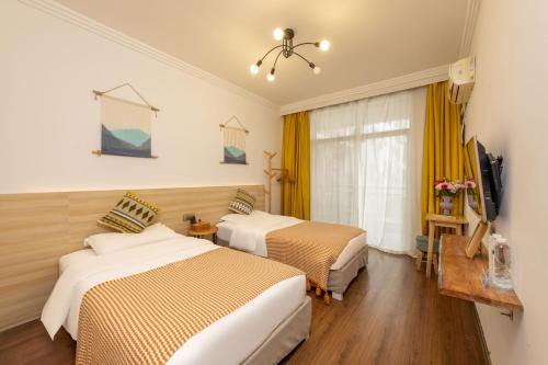 a hotel room with two beds and a television at 悦隐客栈 in Yangshuo